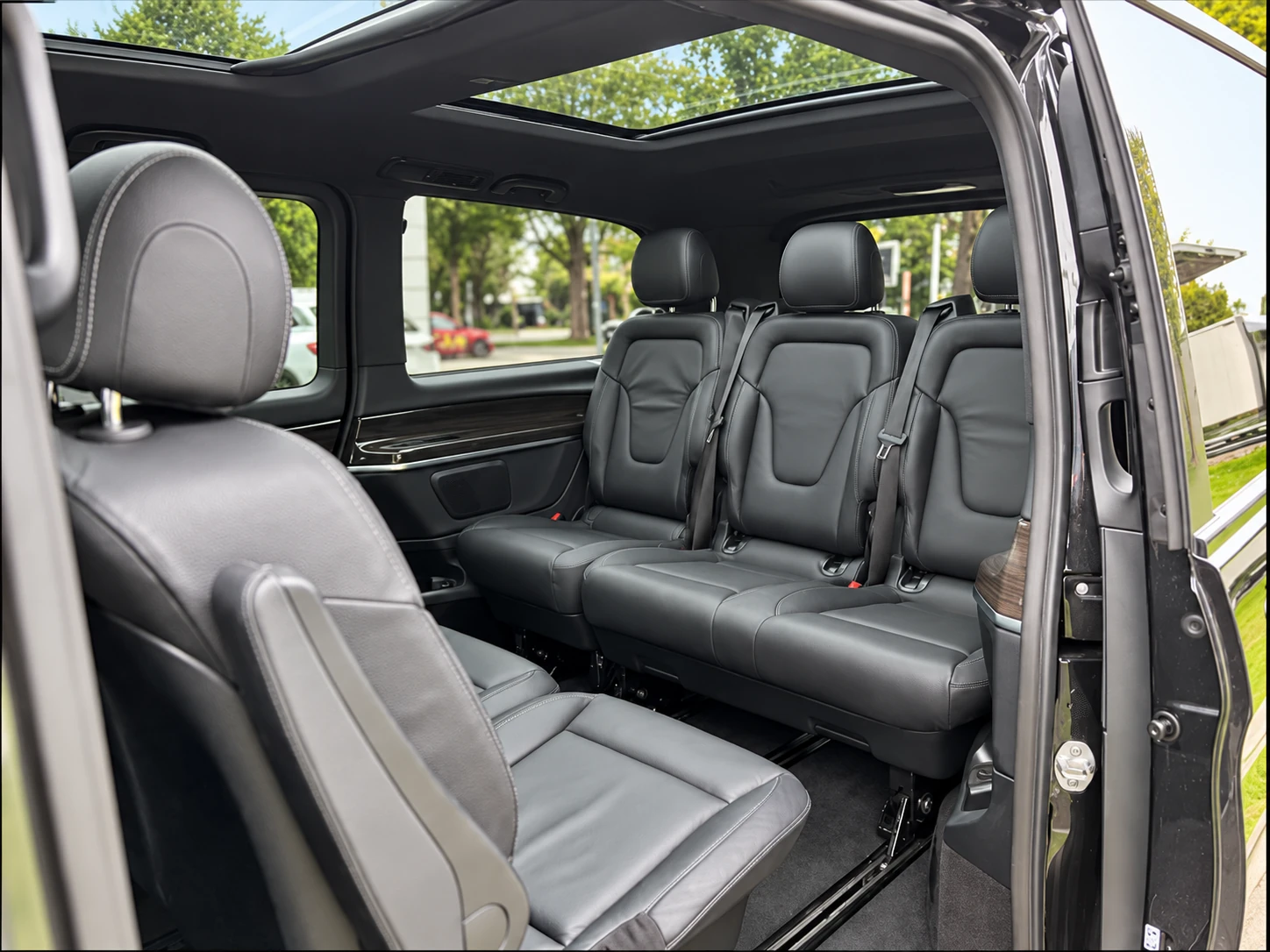 L’intérieur du van Taxi Mood, avec ses sièges en cuir gris et son toit panoramique, vu depuis la porte coulissante ouverte.
